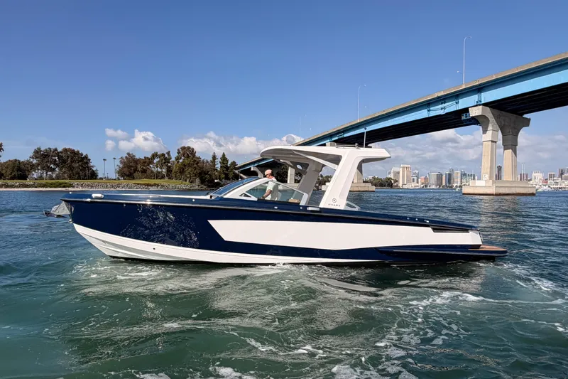 Slide: The Image of 2022 Aviara AV32 I/O boat cruising under a blue bridge on a sunny day. - 37