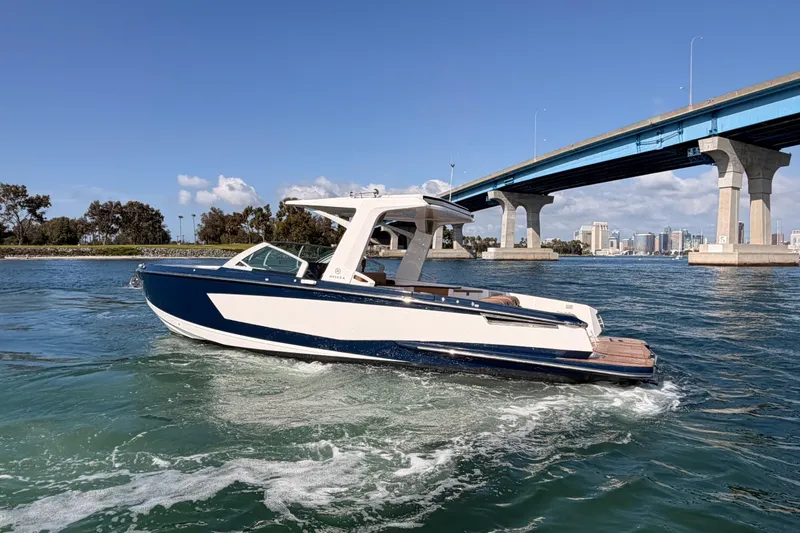 Slide: The Image of 2022 Aviara AV32 I/O boat cruising under a bridge on a sunny day. - 38