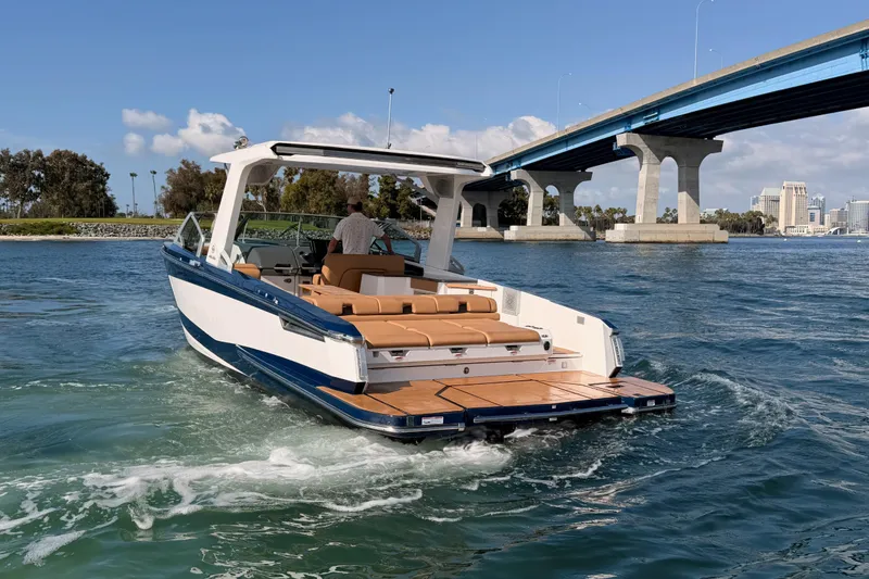 Slide: The Image of 2022 Aviara AV32 I/O boat cruising under a bridge on a sunny day. - 40