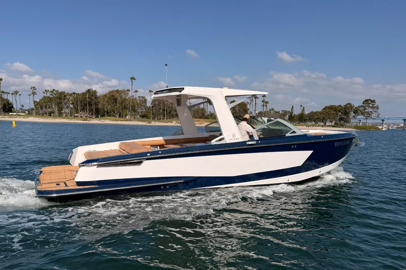 Slide: The Image of 2022 Aviara AV32 I/O boat cruising on a sunny day near a scenic shoreline. - 6