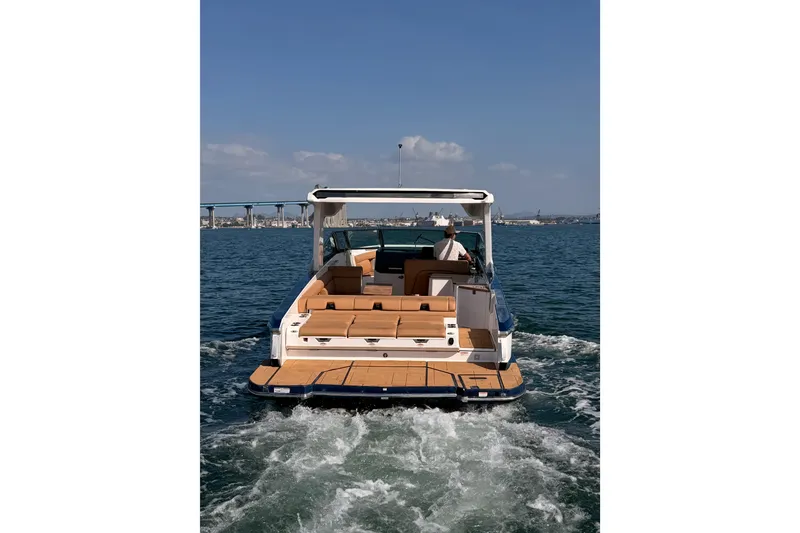 Slide: The Image of 2022 Aviara AV32 I/O boat cruising on open water with scenic bridge view. - 7