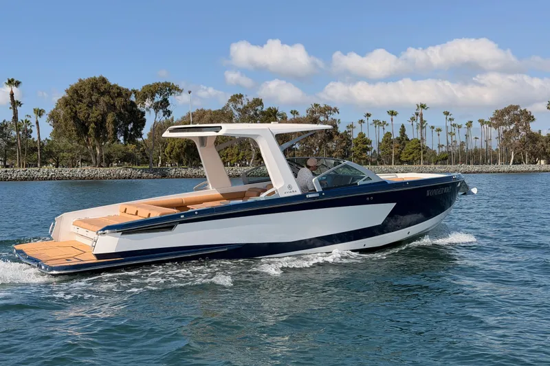 Slide: The Image of 2022 Aviara AV32 I/O boat cruising on a sunny day with scenic background. - 8