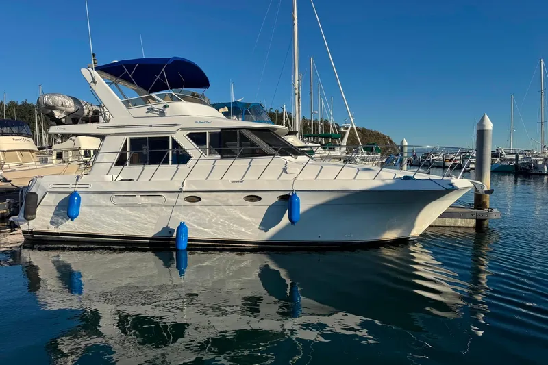 The Image of 2001 Californian 39 yacht docked in marina, reflecting on calm water under clear blue sky. - 0