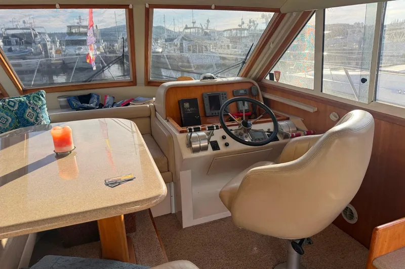 Slide: The Image of Interior of 2001 Californian 39 yacht with helm, table, and scenic marina view. - 10