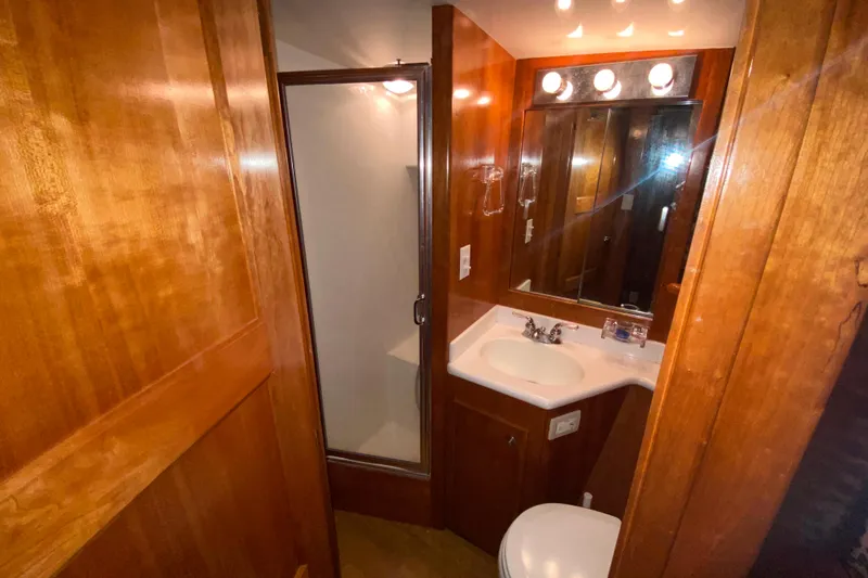 Slide: The Image of Compact bathroom in a 2001 Californian 39 yacht, featuring wood paneling and modern fixtures. - 26