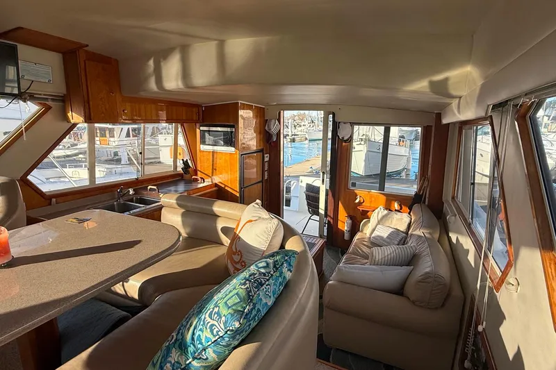 Slide: The Image of Interior of 2001 Californian 39 yacht with cozy seating and marina view. - 9
