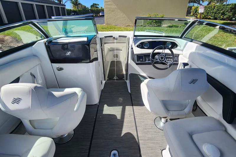 Slide: The Image of 2023 Four Winns HD8 OB boat interior with white seating and modern dashboard. - 20