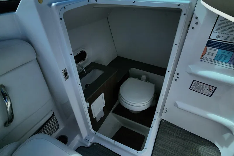Slide: The Image of 2023 Four Winns HD8 OB boat interior with compact marine toilet and sink. - 22