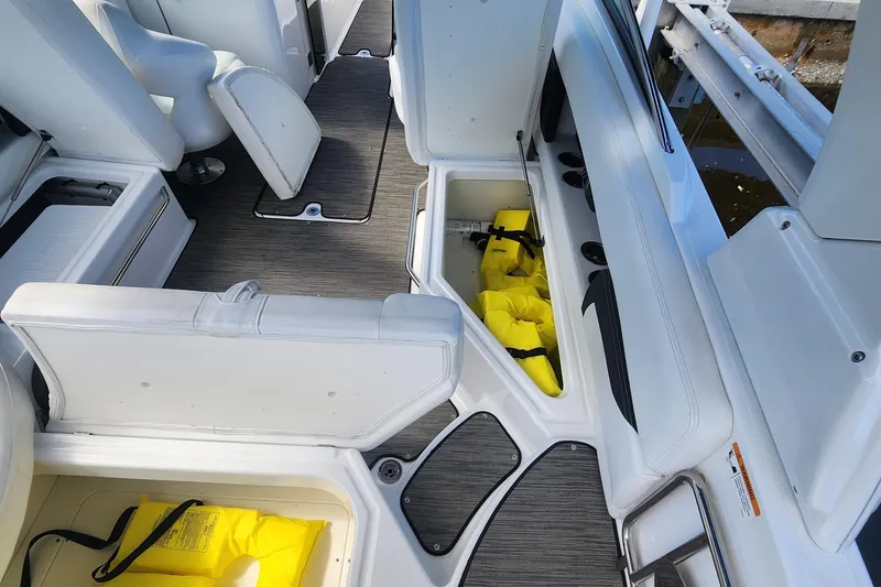 Slide: The Image of 2023 Four Winns HD8 OB boat interior with storage compartments and life jackets. - 30