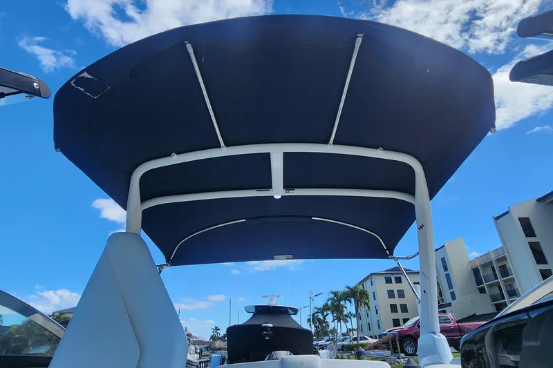 Slide: The Image of 2023 Four Winns HD8 OB boat with canopy, under a clear blue sky. - 34