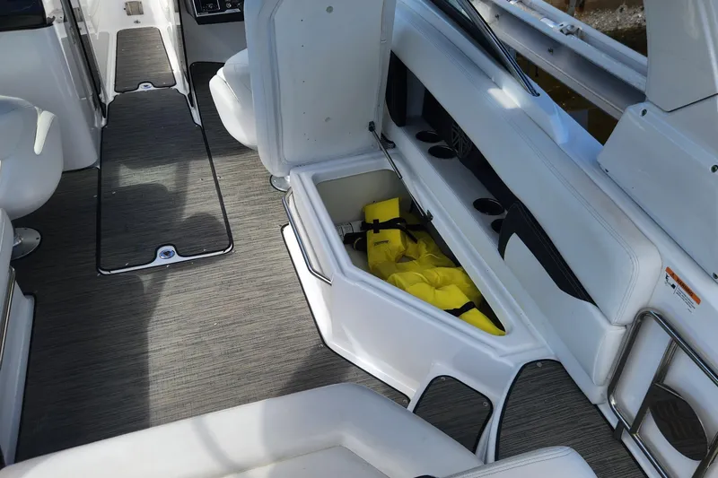 Slide: The Image of 2023 Four Winns HD8 OB boat interior with open storage compartment and life jackets. - 37