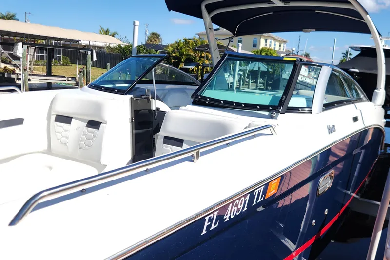 Slide: The Image of 2023 Four Winns HD8 OB boat docked, featuring sleek design and spacious seating. - 4