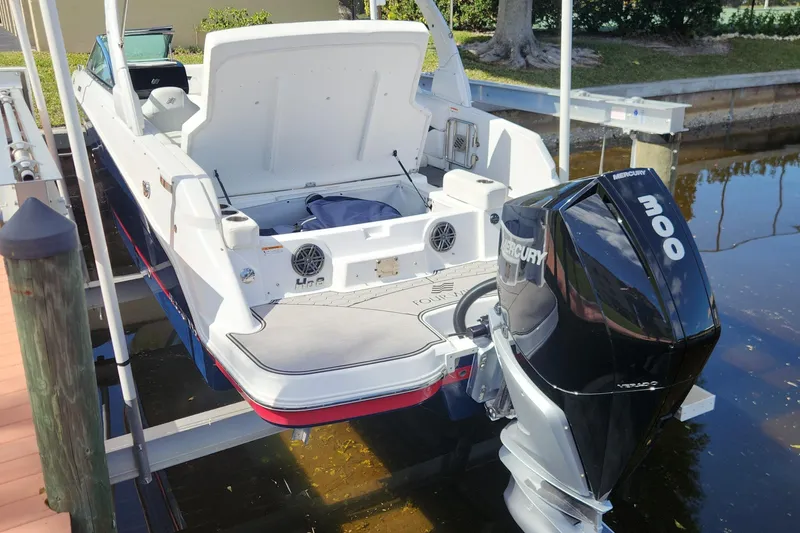 Slide: The Image of 2023 Four Winns HD8 OB boat with Mercury 300 outboard engine docked by the water. - 61