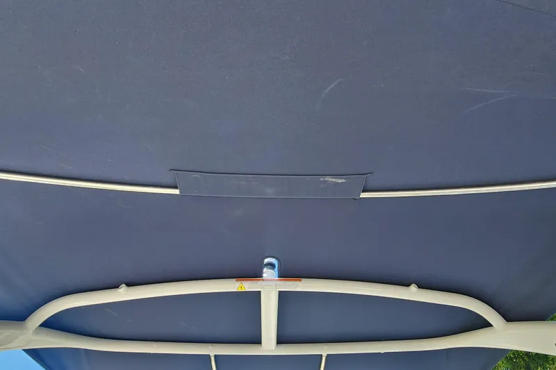 Slide: The Image of Bimini top of 2023 Four Winns HD8 OB boat, featuring sturdy metal frame. - 64