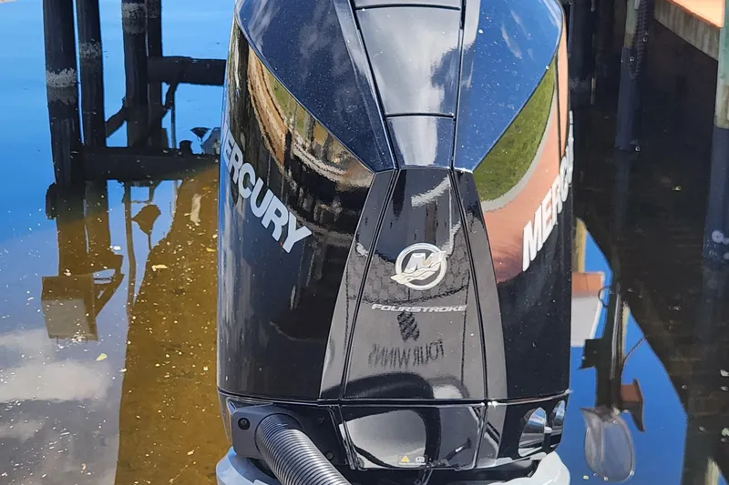 Slide: The Image of Mercury FourStroke outboard motor on 2023 Four Winns HD8 OB boat, docked by water. - 67