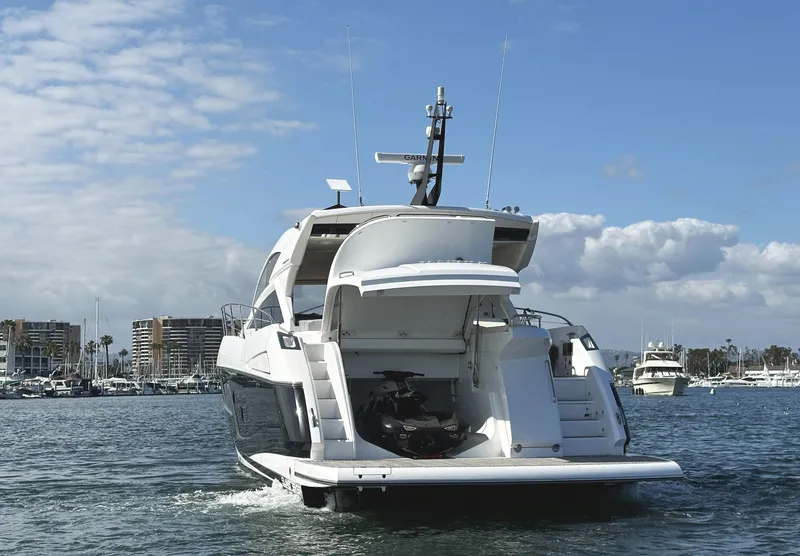 Slide: The Image of 2015 Sunseeker Predator 57 yacht on water, rear view with open garage, clear sky. - 10