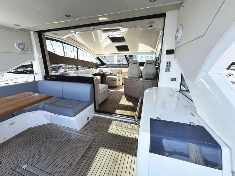 Slide: The Image of 2015 Sunseeker Predator 57 yacht interior with seating and helm, showcasing luxury design. - 12