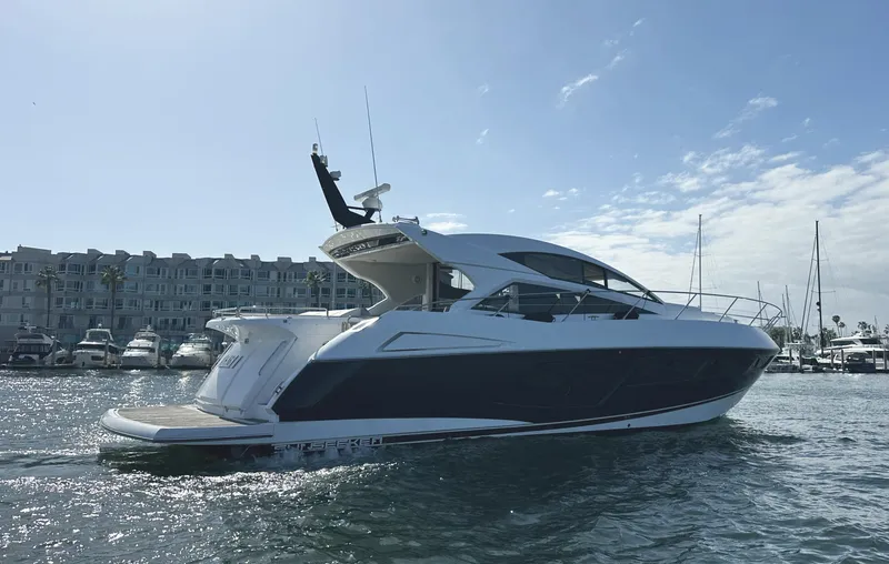 Slide: The Image of 2015 Sunseeker Predator 57 yacht cruising in a marina under a clear sky. - 5