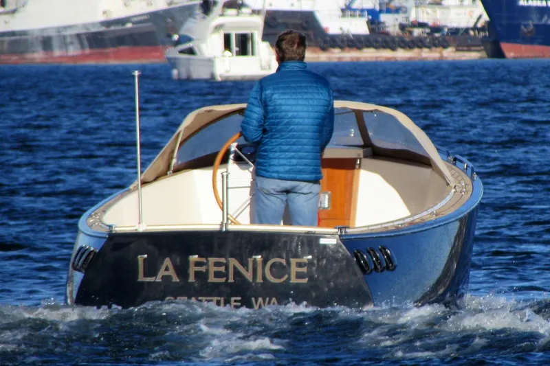 Slide: The Image of Man steering 2014 AdmiralsTender C28 boat named "La Fenice" on water. - 3
