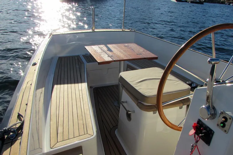 Slide: The Image of 2014 AdmiralsTender C28 boat interior with wooden deck and steering wheel. - 6