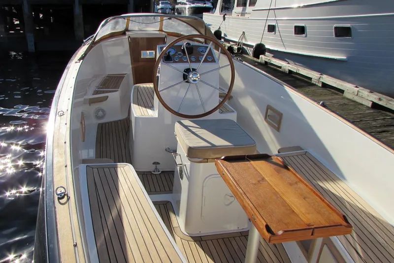 Slide: The Image of 2014 AdmiralsTender C28 boat interior with wooden steering wheel and seating. - 7