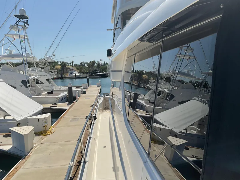 Slide: The Image of 2002 West Bay Sonship yacht docked at a marina, reflecting nearby boats and clear blue sky. - 38
