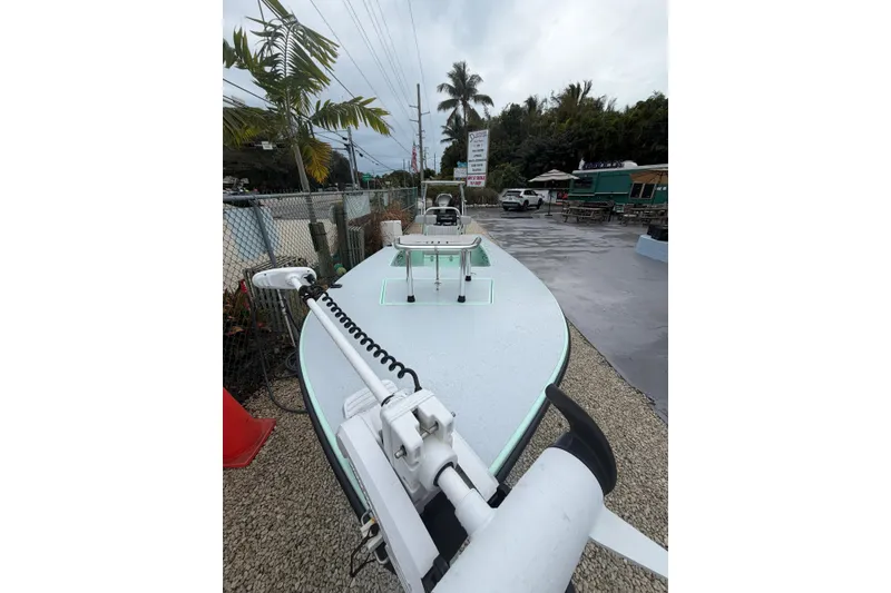 Slide: The Image of 2024 Hell's Bay Professional boat displayed outdoors with palm trees and a sign. - 4