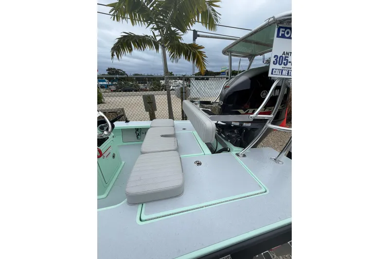 Slide: The Image of 2024 Hell's Bay Professional boat with cushioned seating, palm tree, and Yamaha engine in background. - 5