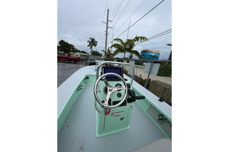 Slide: The Image of 2024 Hell's Bay Professional boat with steering wheel and console, parked outdoors. - 6