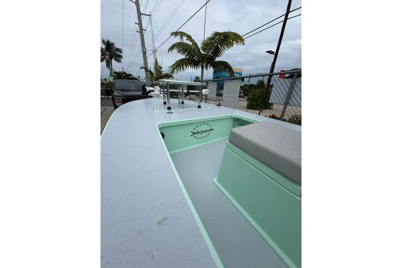 Slide: The Image of 2024 Hell's Bay Professional boat, sleek design, light green interior, outdoor setting. - 8