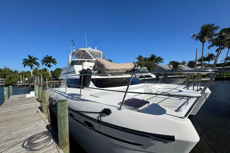 The Image of 2007 Africat Marine 420 yacht docked by palm trees under clear blue sky. - 0