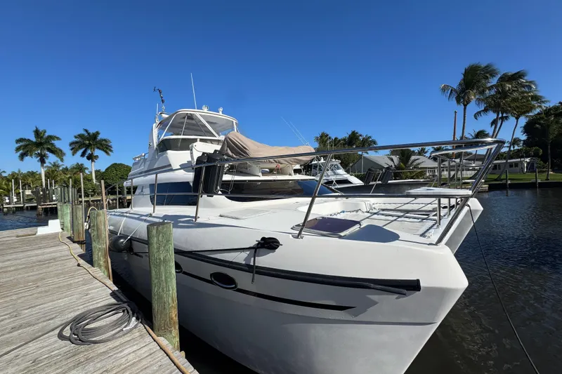 Slide: The Image of 2007 Africat Marine 420 yacht docked by palm trees under clear blue sky. - 103