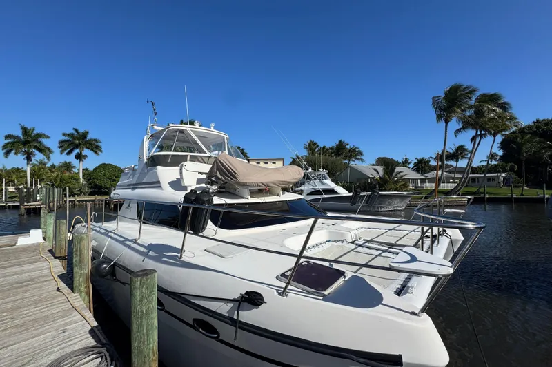 Slide: The Image of 2007 Africat Marine 420 yacht docked by palm trees under clear blue sky. - 104