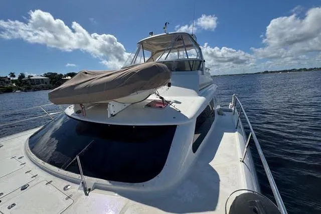 Slide: The Image of 2007 Africat Marine 420 yacht on water, featuring a covered dinghy on deck. - 2