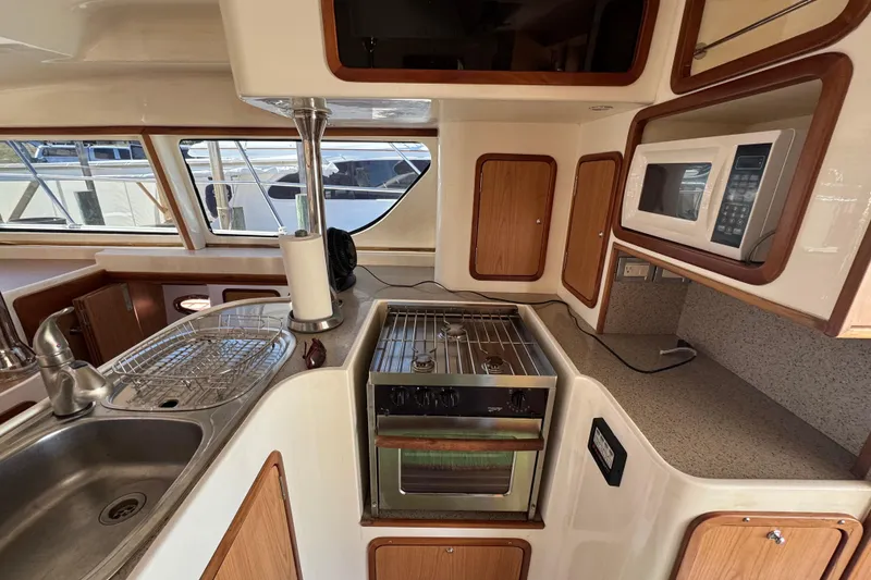 Slide: The Image of Compact kitchen in 2007 Africat Marine 420 yacht with stove, sink, and microwave. - 24