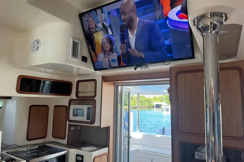 Slide: The Image of Interior of 2007 Africat Marine 420 yacht with TV and kitchen area. - 27