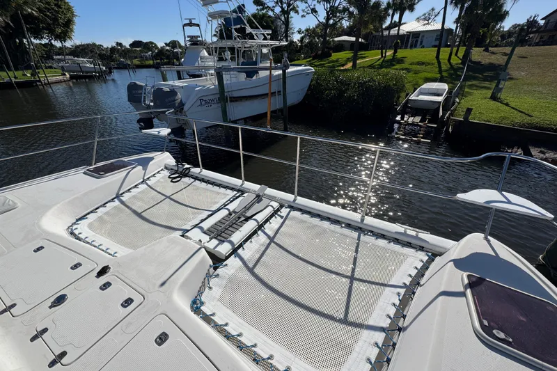 Slide: The Image of 2007 Africat Marine 420 catamaran docked in a sunny marina with lush greenery. - 3