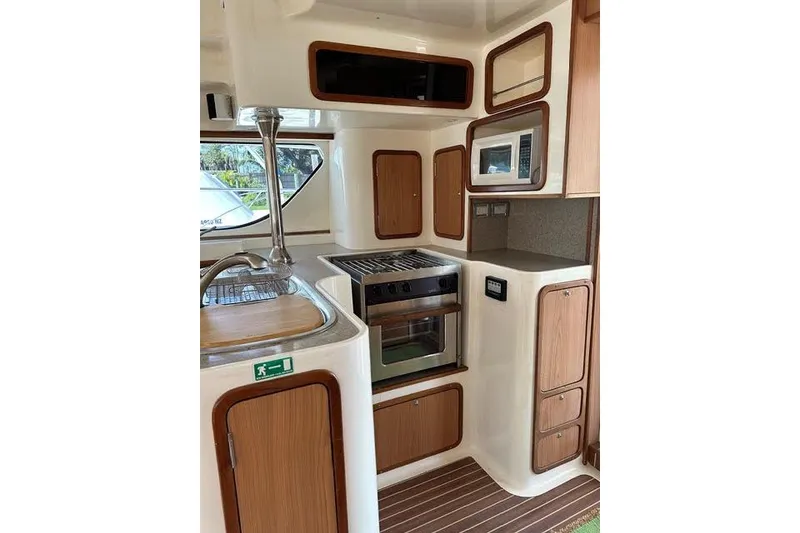 Slide: The Image of 2007 Africat Marine 420 yacht kitchen with stove, microwave, and wooden cabinetry. - 40