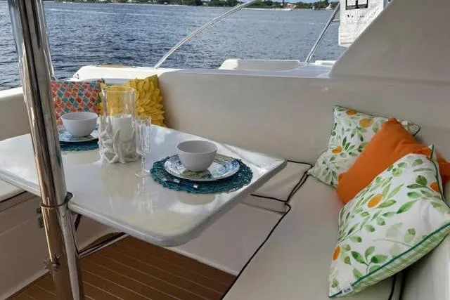 Slide: The Image of Cozy seating area on 2007 Africat Marine 420 yacht with colorful cushions and tableware. - 61
