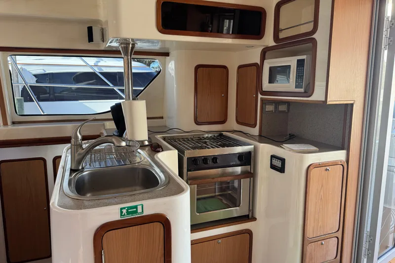 Slide: The Image of Compact kitchen in 2007 Africat Marine 420 yacht with sink, stove, and microwave. - 90