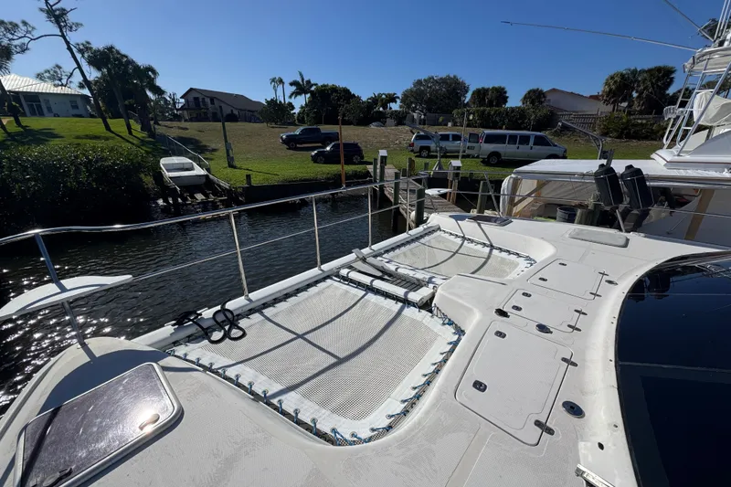 Slide: The Image of 2007 Africat Marine 420 yacht docked by a scenic waterfront with lush greenery. - 92