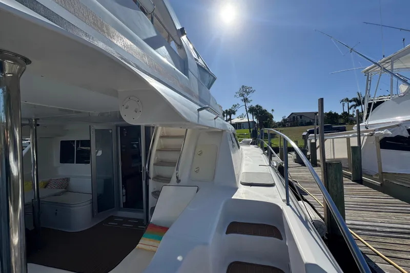 Slide: The Image of 2007 Africat Marine 420 yacht docked under sunny skies, showcasing sleek design and spacious deck. - 97