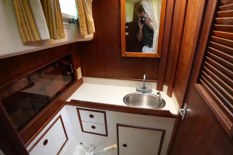Slide: The Image of 1988 Nonsuch 30 Ultra yacht bathroom with wood cabinetry and stainless steel sink. - 18