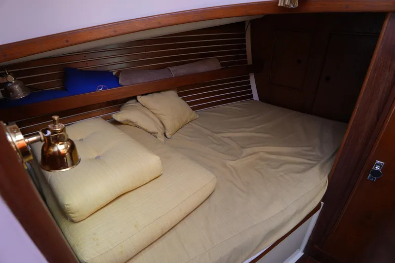 Slide: The Image of Cozy cabin interior of 1988 Nonsuch 30 Ultra sailboat with wooden accents and soft bedding. - 21
