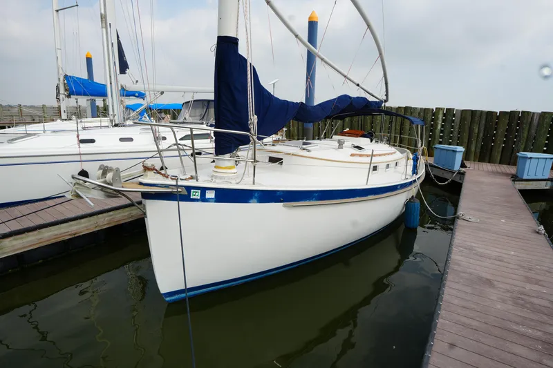 Slide: The Image of 1988 Nonsuch 30 Ultra sailboat docked at marina, featuring blue accents and covered sails. - 4