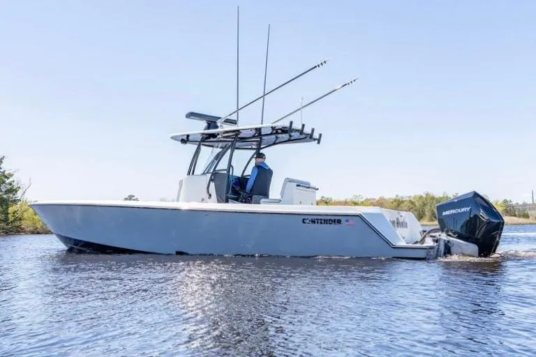 Slide: The Image of 2022 Contender 32 ST boat on water, featuring Mercury engines and fishing rod holders. - 10