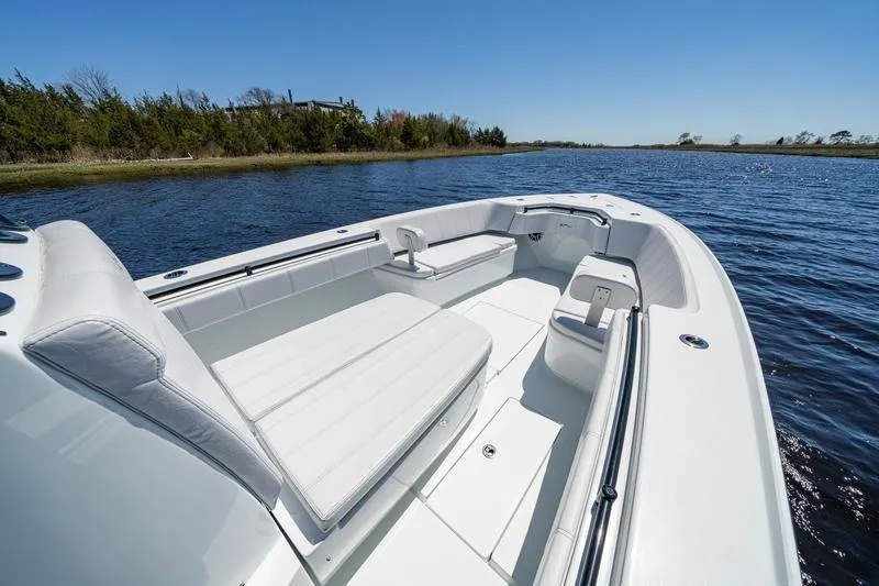 Slide: The Image of 2022 Contender 32 ST boat with white seating on a calm lake. - 15