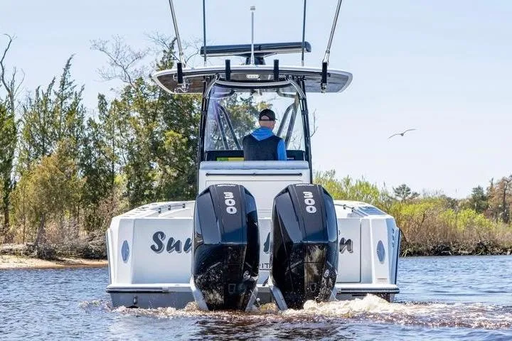 Slide: The Image of 2022 Contender 32 ST boat with dual 300 horsepower engines on a scenic waterway. - 3