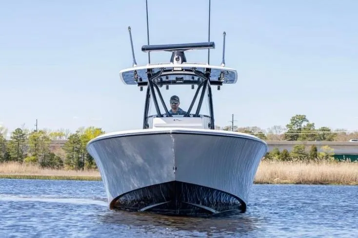 Slide: The Image of 2022 Contender 32 ST boat cruising on a calm waterway, front view. - 6