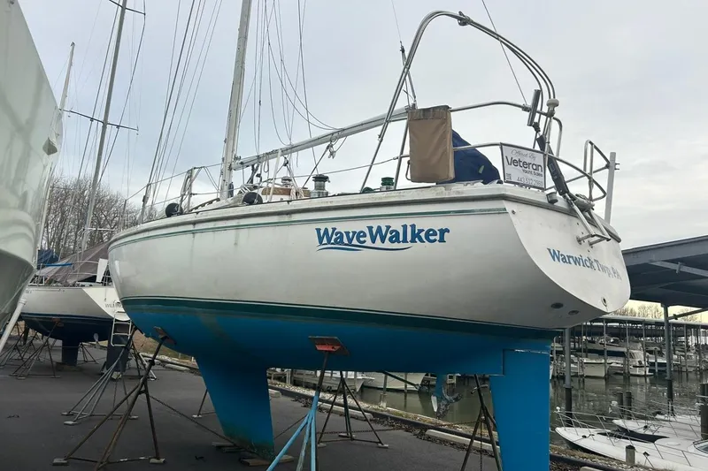 The Image of 1985 Catalina 36 sailboat "WaveWalker" on stands at a marina, ready for maintenance. - 0